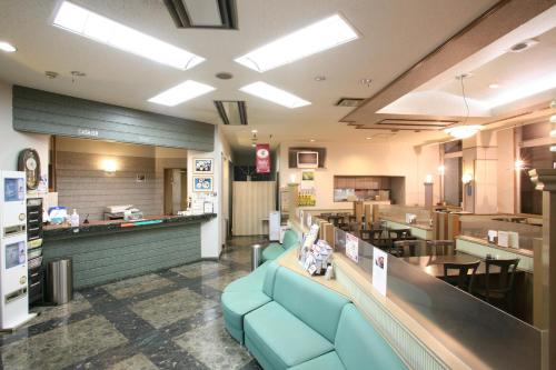 a fast food restaurant with blue chairs and a counter at Tendo Central Hotel in Tendo