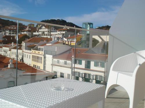 a white table on a balcony with a view of buildings at Hotel Concha in São Martinho do Porto
