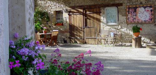 a garden with purple flowers in front of a building at Chambre d'hotes Ferme de la Forlonge in Sauvigny-le-Beuréal