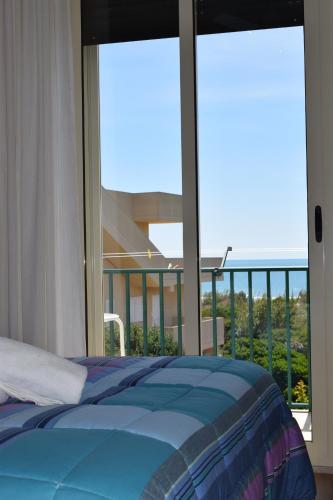 Punta Di Mola في مارينا دي راغوزا: غرفة نوم مع سرير وإطلالة على المحيط