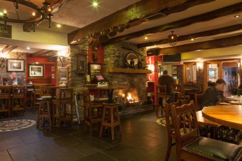 a restaurant with a fireplace and tables and chairs at Mills Inn in Ballyvourney