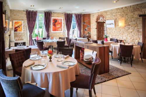 a restaurant with tables and chairs in a room at La Marande in Montbellet