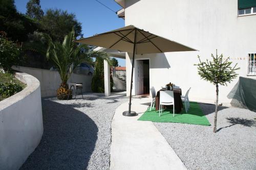 a table with an umbrella next to a building at Vila Teixeira in Amarante