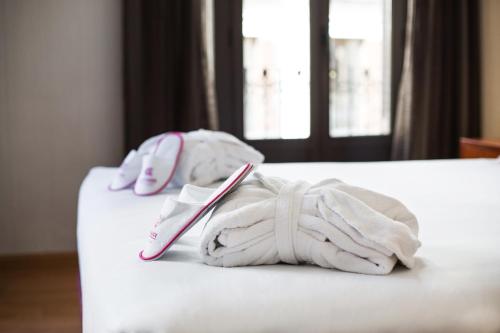 dwa ręczniki na łóżku w obiekcie Petit Palace Preciados w Madrycie