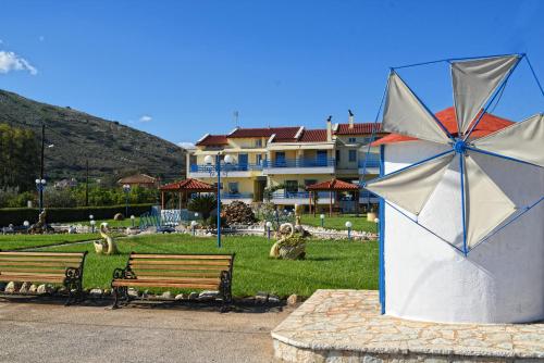 a park with two park benches and a building at Akrogiali in Míloi