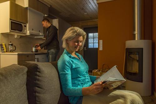 a woman sitting on a couch using a laptop at Valkea Arctic Lodge in Pello
