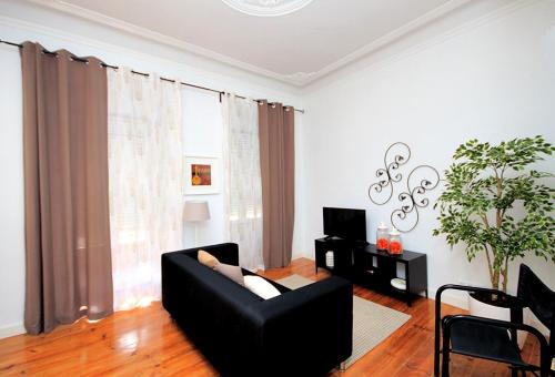 a living room with a black couch in front of a window at Lisbon Lights Apartments in Lisbon