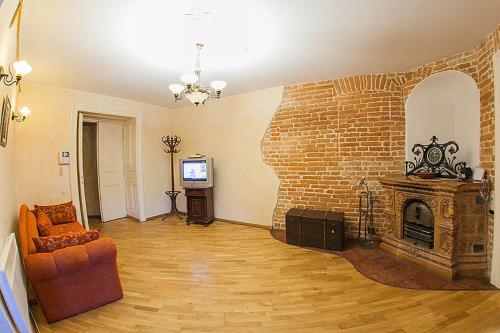 リヴィウにあるHistoric Apartment near Rynor Squareのリビングルーム(レンガ造りの暖炉、ソファ付)