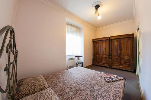 リヴィウにあるHistoric Apartment near Rynor Squareのベッドルーム1室(ベッド1台付)、木製キャビネットが備わります。