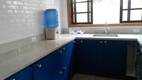 una cocina con armarios azules y fregadero en Casa Centro De Ubatuba en Ubatuba