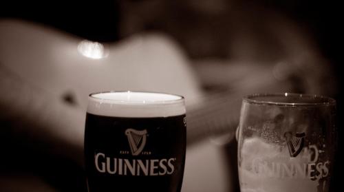 a glass of beer sitting next to a candle at Mills Inn in Ballyvourney