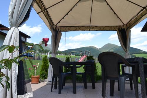 a table and chairs on a patio with mountains in the background at Häuslerhof in Maranza