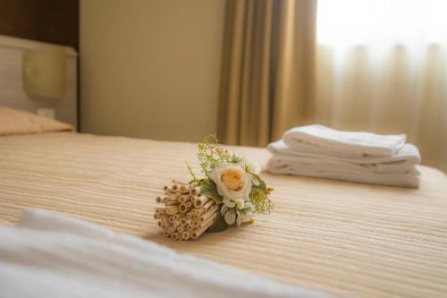 un pequeño ramo de flores en una cama en Affittacamere Dell'Autista, en Brugnato