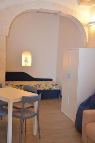 オストゥーニにあるLA CASETTA 2.0のベッド、テーブル、椅子が備わる客室です。