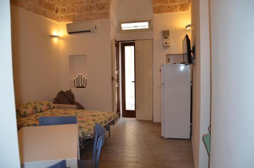 a living room with a table and a refrigerator at LA CASETTA 2.0 in Ostuni