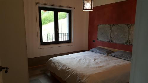a bedroom with a bed and a window at Rocca d'Anfo B&B-Apartments Lake View in Rocca dʼAnfo