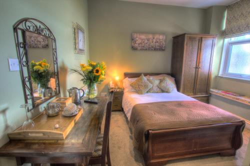 a bedroom with a bed and a table and a desk at Dunster Castle Hotel in Dunster