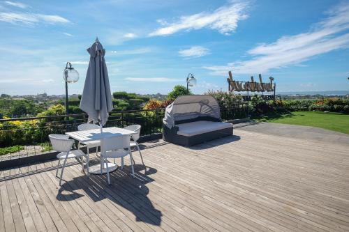 a patio with an umbrella and a table and chairs at Jambuluwuk Oceano Seminyak Hotel in Seminyak