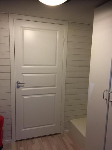 eine weiße Tür in einem Zimmer mit einem Schrank in der Unterkunft Klitterbyn Lodge in Ängelholm