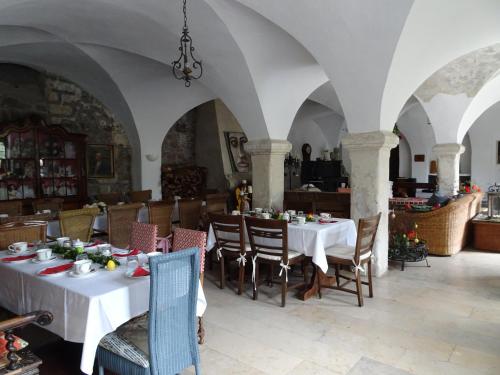 un comedor con mesas y sillas blancas en Pension zur Königlichen Ausspanne Dresden, en Dresden