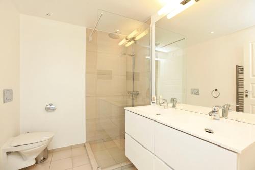 CPH Lux apartm, 2 FULL BATHROOMS 2th في كوبنهاغن: حمام أبيض مع حوض ومرحاض