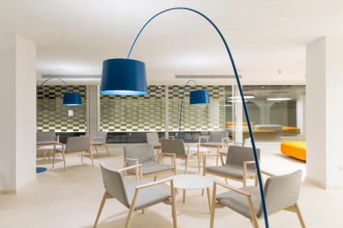 a room with chairs and a table and blue lights at Ebano Hotel Apartments & Spa in Playa d'en Bossa