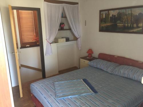 a small bedroom with a bed and a window at Guest House Mareda Palms in Novigrad Istria