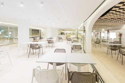 an empty restaurant with tables and chairs at Ebano Hotel Apartments & Spa in Playa d'en Bossa