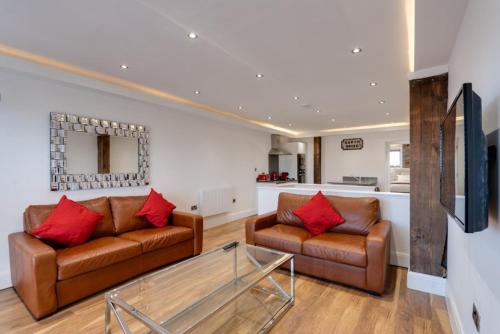 a living room with two couches and a glass table at The Picture House Apartments in Liverpool