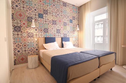 um quarto com uma cama com uma parede colorida em Páteo Saudade Lofts Marquês em Lisboa