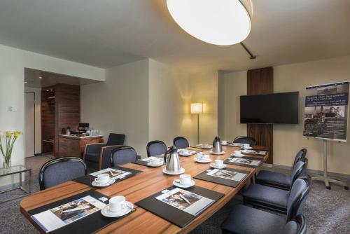 a conference room with a long table and chairs at Maritim Hotel München in Munich