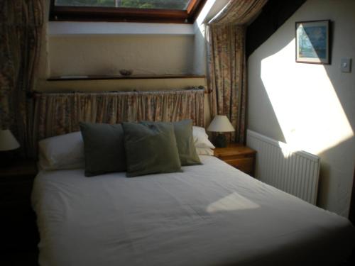 a bedroom with a white bed with a window at The Black Bull Inn and Hotel in Coniston