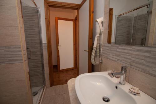 a bathroom with a sink and a shower and a mirror at Club Esse Sporting in Stintino