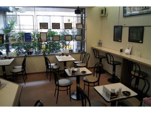 uma sala de jantar com mesas e cadeiras num restaurante em Nishishinjuku Green Hotel em Tóquio