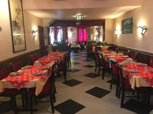 une salle à manger avec tables et chaises et nappes rouges dans l'établissement Belle d'Asie, à Longué