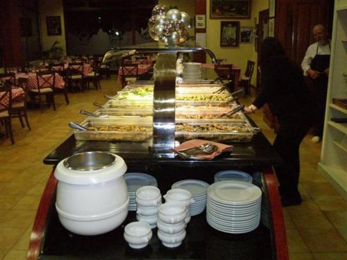 a buffet line with dishes and food on a table at Hotel Bon Repos in Bellver de Cerdanya 