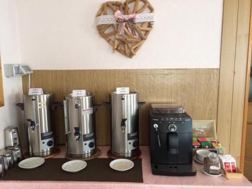 een aanrecht met drie koffiezetapparaten en een hart aan de muur bij Garnì Serena in Canazei