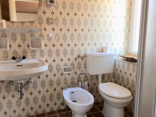 a bathroom with a toilet and a sink at Garnì Serena in Canazei