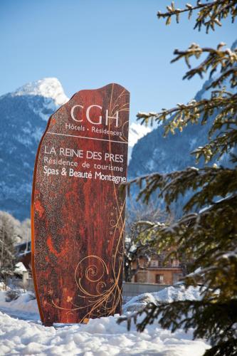 a snowboard sitting in the snow next to a tree at CGH Résidences & Spas La Reine des Prés in Samoëns