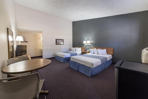 Parkview Inn and Conference Center في الينتاون: غرفة فندقية بسريرين وطاولة