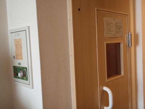 a wooden door with a window in a room at Nishishinjuku Green Hotel in Tokyo