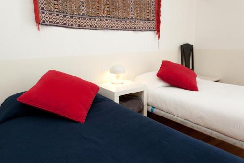 Pokój z 2 łóżkami z czerwonymi poduszkami w obiekcie Penthouse Vallespir w Barcelonie