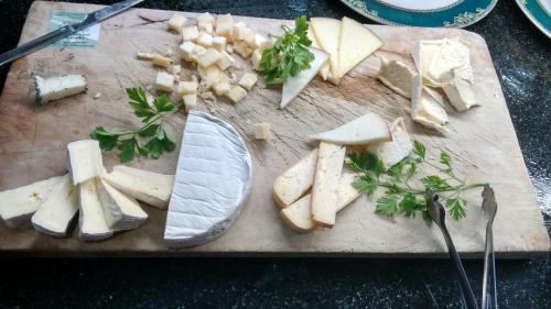 a cutting board with cheese and vegetables on it at Hotel Bon Repos in Bellver de Cerdanya 