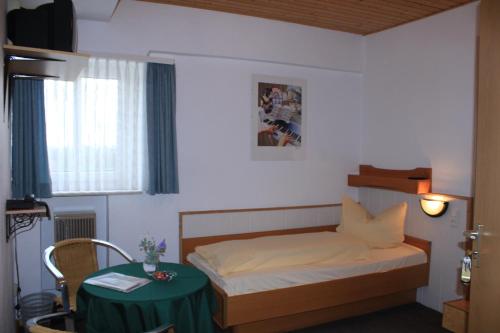 a small bedroom with a bed and a table at Gasthof Neusitz in Neusitz