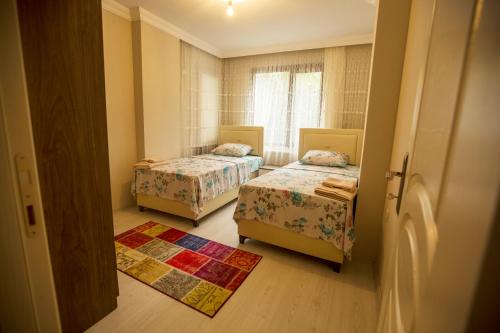 トラブゾンにあるKorkmaz Apartのベッド2台と窓が備わる小さな客室です。