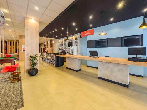 a lobby of a store with a counter and chairs at ibis Jacarei in Jacareí