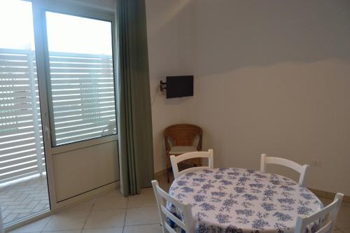 a dining room with a table and chairs and a window at A casa di Elena in Leuca