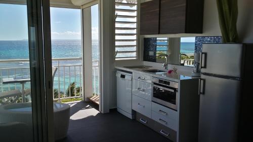a kitchen with a refrigerator and a view of the ocean at So Chic in Saint-François