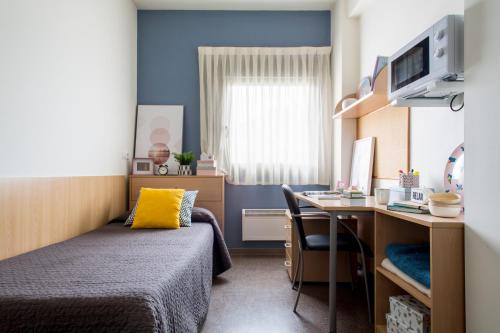 1 dormitorio con 1 cama y escritorio con ordenador en Residencia Universitaria As Burgas, en Ourense