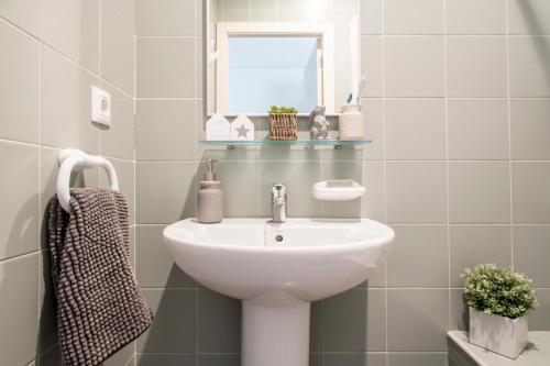 a white bathroom with a sink and a mirror at Residencia Universitaria As Burgas in Ourense